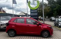 Roter KIA Picanto in Seitenansicht vor dem Autohaus Richter & Zech.