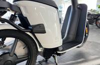 Nahaufnahme der weißen Verkleidung und des Vorderrads eines E-Scooters.