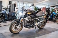 Eine schwarze und goldfarbene E-Motorrad steht in einem Showroom.
