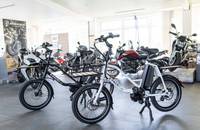 Schwarzes E-Lastenrad (E-Packr 8.0) in einer Innenraum-Ausstellung.