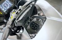 Nahaufnahme des Lenkers und des Ladeanschlusses an der Front des Motorrads.