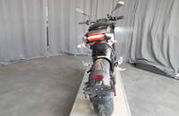 Heckansicht eines schwarzen Motorrads mit Heckleuchten und Hinterrad.