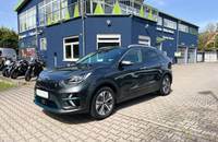 Außenansicht eines dunkelgrauen KIA E-Niro Electric vor einem Autohaus.