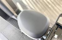 Nahaufnahme eines grauen, gepolsterten Sitzs im Innenraum eines Elektrofahrzeugs.