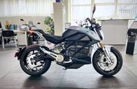 Seitenansicht eines silbernen E-Motorrads in einem Autohaus.
