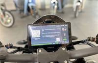 Nahaufnahme des digitalen Displays eines E-Scooters mit Startanleitung und 100% Akkustand.
