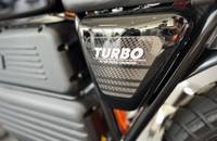 Nahaufnahme eines Seitenspiegels mit einem Aufkleber, der "TURBO 45 kW MEGA CHARGED" zeigt.