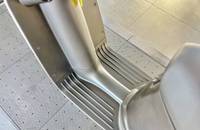 Nahaufnahme des Innenraums, die einen metallenen Bodenbelag, eine Seitenkonsole und einen Teil des Sitzbereichs zeigt.
