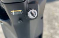 Detailaufnahme eines Warnhinweises und eines Drehreglers an der Fahrzeugverkleidung.