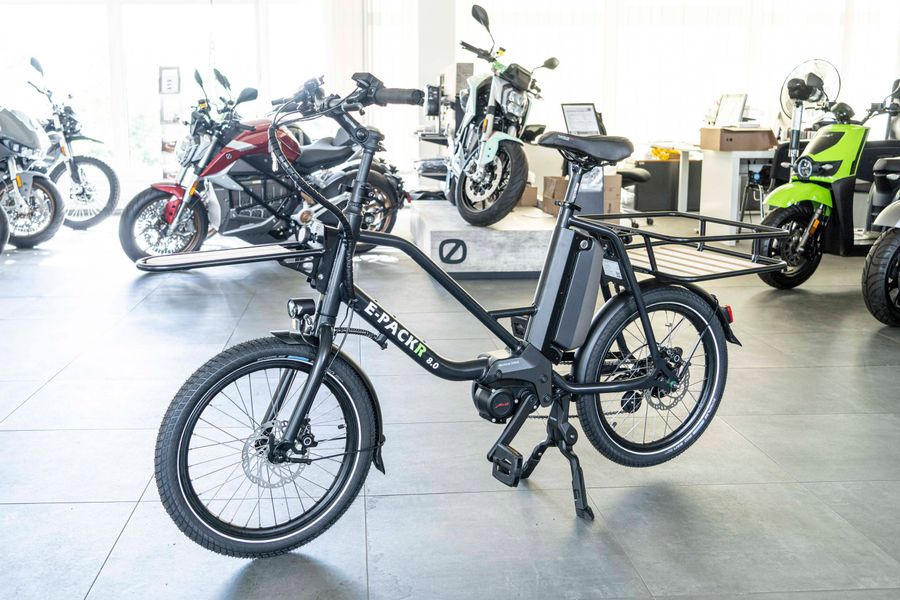 Außenansicht eines schwarzen E-Cargo-Bikes (E-PACKR 8.0) in einem Showroom.