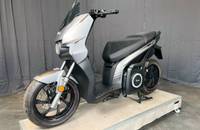 Elektrischer Scooter in Grau, Seitenansicht, präsentiert auf einem erhöhten Podest.