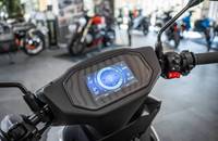 Digitales Cockpit eines Motorrads mit Anzeigen für Geschwindigkeit, Akku und Temperatur.