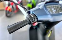 Nahaufnahme des Lenkers und des Bedienfeldes eines E-Scooters mit Blinker und Display.