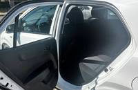 Die offene Fahrertür eines weißen KIA Picanto zeigt den Innenraum.