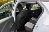 Innenraumansicht eines weißen Opel Corsa mit sichtbaren Vordersitzen und Armaturenbrett.