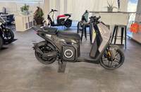Seitenansicht eines grauen elektrischen Scooters (SILENCE S02) in einem Showroom.
