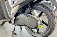 Nahaufnahme des Hinterrads und des Antriebsgehäuses eines E-Scooters. Sichtbar sind Federung und Reifen.