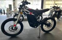 Seitenansicht eines weißen E-Motorrads (ZERO) in einem Showroom.