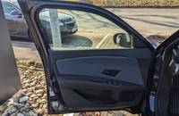 Offene Fahrertür des Nissan Micra EV mit Blick auf den Parkplatz.