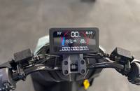 Nahaufnahme des digitalen Tachoanzeiges eines E-Scooters mit Ladestand und Temperatur.
