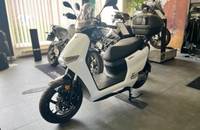 Außenansicht eines weißen E-Motorrollers in einem Showroom.