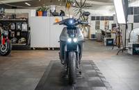 Draufsicht auf das graue E-Motorrad RAY 7.7, das in einem Showroom steht.