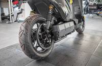 Nahaufnahme des Hinterrads und des unteren Verkleidungsbereichs eines elektrischen Rollers.