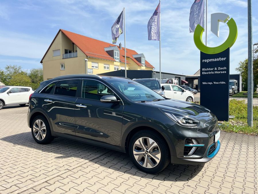 Ein dunkelgrauer KIA Niro Electric steht vor dem Autohaus Richter & Zech.