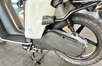 Nahaufnahme des vorderen Rades, der Federung und des Akkugehäuses eines weißen E-Scooters.