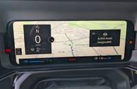 Digitales Cockpit eines Elektroautos mit Navigationskarte und Ladestandanzeige.