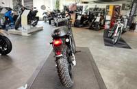 Ein schwarzes E-Motorrad der Marke RGNT steht auf einer Plattform in einem Autohaus.