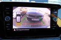 Infotainment-Bildschirm eines Autos, der eine Fahrwegkontrolle anzeigt. Das Fahrzeug ist auf einem gepflasterten Boden z