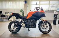 Seitenansicht eines orangefarbenen E-Motorrads (ZERO) in einem Showroom.