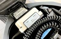 Nahaufnahme des Ladeanschlusses des Elektrofahrzeugs mit digitalen Anzeigen für Leistung und Ladezustand.