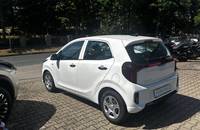 Weiße KIA Picanto Außenansicht von der Rückseite auf einem Autohausparkplatz.