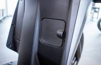 Detailaufnahme eines grauen Fahrzeugpanels mit einem rechteckigen Anschlussdeckel.