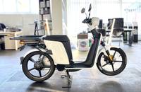 Ein weißer Elektroroller (eSPro 45) wird in einem hellen Showroom aufgestellt.