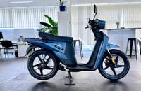 Seitenansicht eines blauen Elektrorollers (ANDERE NGS3) in einem Showroom.
