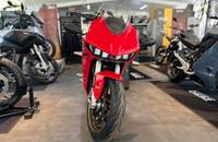 Rotes Motorrad im Showroom, frontal aufgenommen.