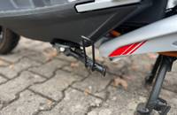 Detailansicht des hinteren Kotflügels und des Seitenständers eines Piaggio-Scooters.