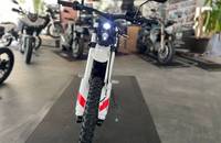 Frontalansicht eines weißen E-Motorrads in einem Showroom.