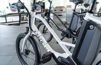 Nahaufnahme von mehreren E-Bikes in einem Showroom, die Rahmen und Räder zeigen.