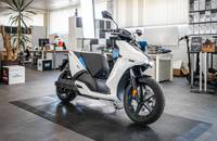 Weißer Elektroroller (RAY 7.7) in einer Seitenansicht im Showroom.