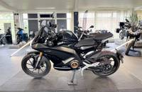 Schwarzes Motorrad (VMOTO STASH) in Seitenansicht in einem Showroom.
