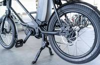Seitenansicht eines schwarzen E-Lastenrads, das auf einem Ständer steht.