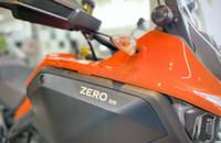 Nahaufnahme der orangefarbenen Frontpartie eines Scooters mit Scheinwerfer und Lenker.