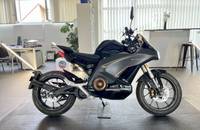 Seitenansicht eines schwarzen E-Motorrads in einem Showroom.