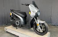 Grauer elektrischer Roller (Silence S01 Plus) auf einer erhöhten Präsentationsplattform.