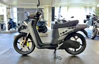 Seitenansicht eines grauen Elektro-Scooters (Askoll NGS3) auf einem Fliesenboden in einem Showroom.