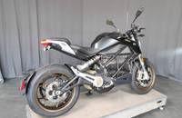 Schwarzes E-Motorrad (ZERO) in Außenansicht auf einer erhöhten Plattform.
